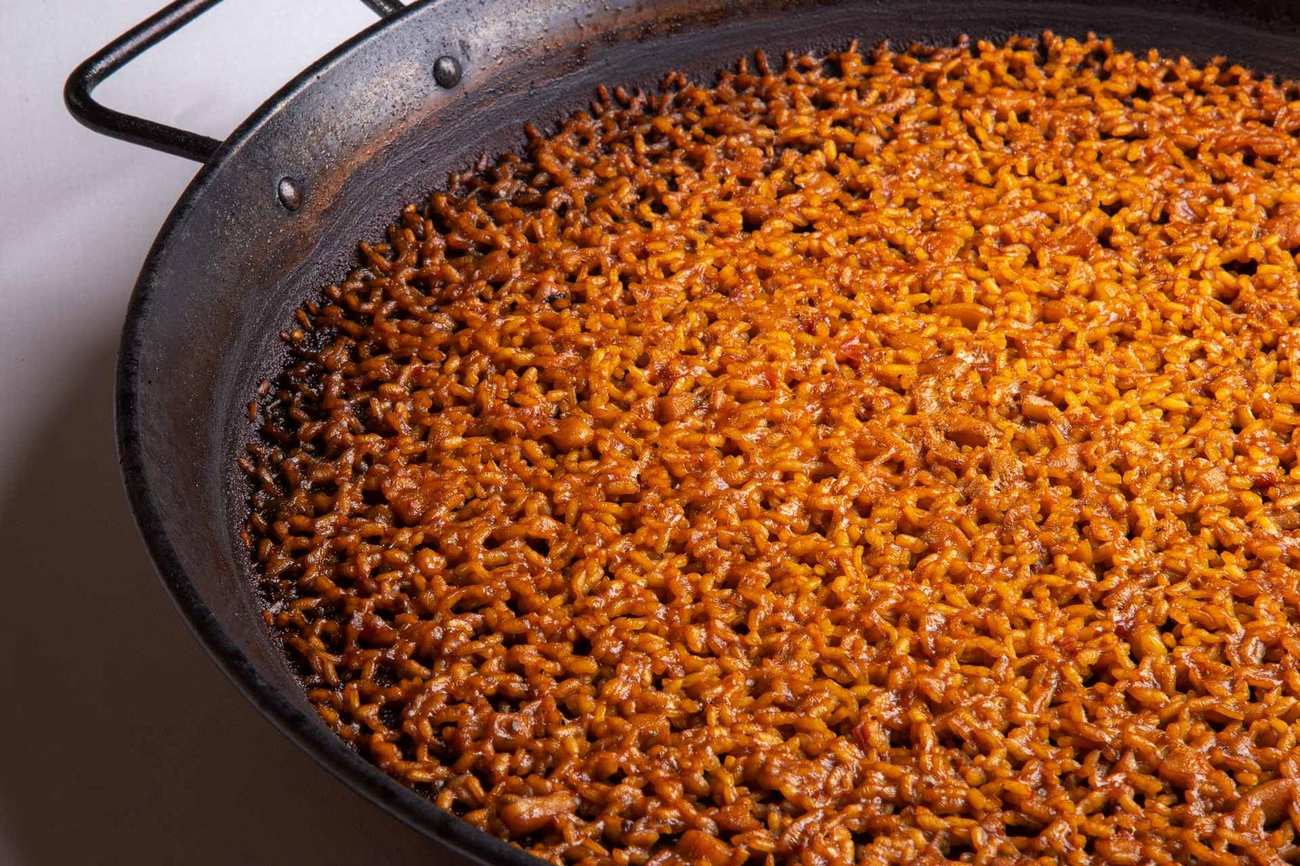 A paella pan of golden rice with socarrat around the edge